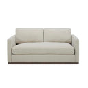 Front view of a Bobbi upholstered loveseat in a light beige or cream-colored fabric, with two loose back cushions, a single bench seat cushion, slim arms, and a dark, continuous wooden base.
