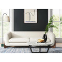 The Amala sofa styled in a modern living room with a dark accent wall, abstract art, and a marble coffee table, showcasing its organic design.