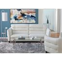 A front view of the Bianca contemporary sofa, featuring white leather upholstery, plush horizontal channel-tufted back cushions, and slender tapered legs on a living room setup.