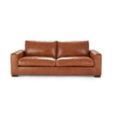 A front view of the Kennon contemporary leather sofa in a cognac color, featuring wide track arms, plush cushions, and low block feet, on a white background.