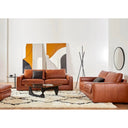 The Kennon leather sofa and loveseat styled in a modern living room with abstract art, a shaggy rug, and a contemporary floor lamp.