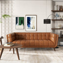 Cognac leather sofa in a modern living room with decor elements.