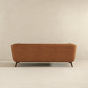 Cognac leather sofa against a beige wall