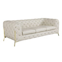 Three-quarters view of a beige tufted sofa with gold legs on a white background.