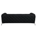 Rear view of a black tufted sofa with chrome legs on a white background.