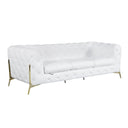 Three-quarters view of a white tufted sofa with gold legs on a white background.