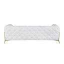 Rear view of a white tufted sofa with gold legs on a white background.