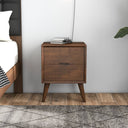 Wooden nightstand with two drawers next to a bed in a bedroom setting.