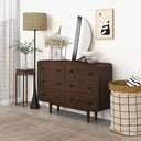 Wooden dresser in a room with decor elements like a lamp, plant, and wall art.
