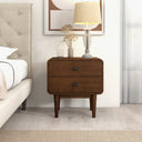 Wooden nightstand with lamp and decorative items in a bedroom setting