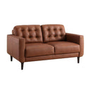 Three-quarters view of an Armando mid-century modern loveseat in cognac brown leather, featuring two biscuit-tufted back cushions, plain seat cushions, track arms, and angled dark wood legs.