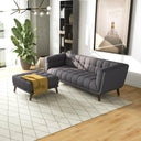Dark gray tufted sofa with yellow blanket in a modern living room setting.