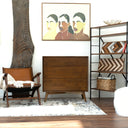 Living room with wooden dresser, chair, and wall art
