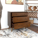 Wooden dresser with open drawers in a room with a rug and wall art.