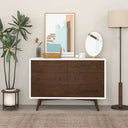Wooden dresser with white top in a room with decor elements like a plant, mirror, and lamp.