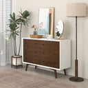 Wooden dresser with white top in a room with decor elements like a plant, mirror, and lamp.