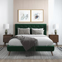 Green upholstered bed in a bedroom with matching nightstands and artwork on the wall.