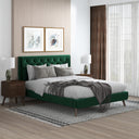 Modern bedroom with a green upholstered bed, wooden nightstands, and framed artwork on the wall.
