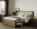 A modern, low-profile bed with a curved, solid wood frame and a beige fabric upholstered headboard in a living room.