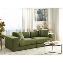 Green sofa in a living room with a coffee table and decorative items.