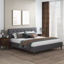 Modern bedroom with a dark gray upholstered bed, wooden nightstands, and decorative pillows.