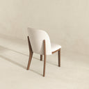 Soft beige chair with wooden legs on a beige background