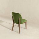 Green chair with wooden legs on a beige background