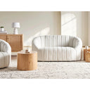 Modern living room with off-white sofa, wooden coffee table, and wicker cabinet.