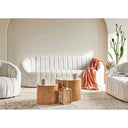 Modern living room with off-white sofa, wooden coffee tables, and decorative items.