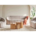 Modern living room with beige sofa, armchair, and coffee tables.