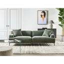 Contemporary living room with a green sofa, glass coffee table, and decorative elements.