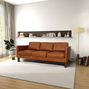 Cognac leather sofa in a modern living room with a white wall and wooden floor.