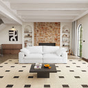 Modern living room with white loveseat, black coffee table, and brick wall.