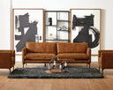 Modern living room with brown leather sofa, armchairs, and abstract art on a white wall.