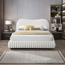 Modern bedroom with a cream upholstered bed, nightstands, and decorative items.
