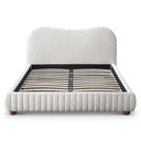 Cream upholstered bed with wooden legs on a white background