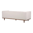 Three-quarters rear view of a Skaule mid-century modern sofa in an off-white textured fabric, with vertical channel stitching on the back and inner arms, two seat cushions with piping, and a dark wood base with tapered legs.