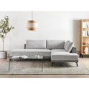 Gray sectional sofa in a modern living room with a glass coffee table and decorative items.