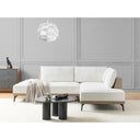 Modern living room with an off-white sectional sofa, black coffee table, and decorative items.