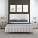 Cream upholstered bed with green bedding in a bedroom setting.