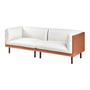 Three-quarters view of an off-white sofa with brown leather covered wooden frame with black metal legs on a white background.