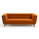 Adele 85-inch mid-century modern sofa in burnt orange velvet with grid tufting and tapered wooden legs, isolated on a white background.