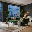 Adele 85-inch emerald green velvet sofa with tufted cushions in a modern living room featuring a marble coffee table, fiddle leaf fig plants, and a large window showing a city skyline at night.