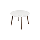 Modern round dining table featuring a smooth white circular tabletop supported by four angled dark wood legs against a white background.
