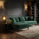 Bayley 107-inch dark green velvet left-facing sectional sofa with chaise lounge and wooden legs, styled on a vintage rug in a moody dark living room.