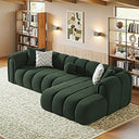  Bella 114-inch dark green French bouclé right-facing sectional sofa with curved channel tufting, styled with decorative pillows on a patterned rug in a modern living room.