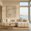 Bella 114-inch ivory tufted bouclé right-facing sectional sofa with channel tufting and rounded arms in a minimalist coastal living room overlooking the ocean.