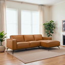 Berry 102-inch cognac brown vegan eco-leather right-facing sectional sofa with black metal legs in a modern sunlit living room.