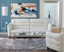 A front view of the Bianca contemporary sofa, featuring white leather upholstery, plush horizontal channel-tufted back cushions, and slender tapered legs on a living room setup.