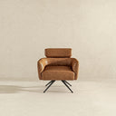 Camila modern swivel accent chair upholstered in tan genuine leather, featuring curved sloping arms, a cushioned seat, and a horizontal headrest cushion supported by a four-star black metal splayed base against a neutral textured beige background.